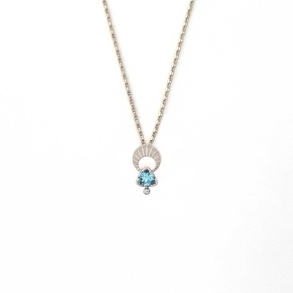 Crescent moon charm necklace with a trillion aquamarine and diamond pendant on a white background | Camille Torres Designs