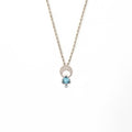 Crescent moon charm necklace with a trillion aquamarine and diamond pendant on a white background | Camille Torres Designs