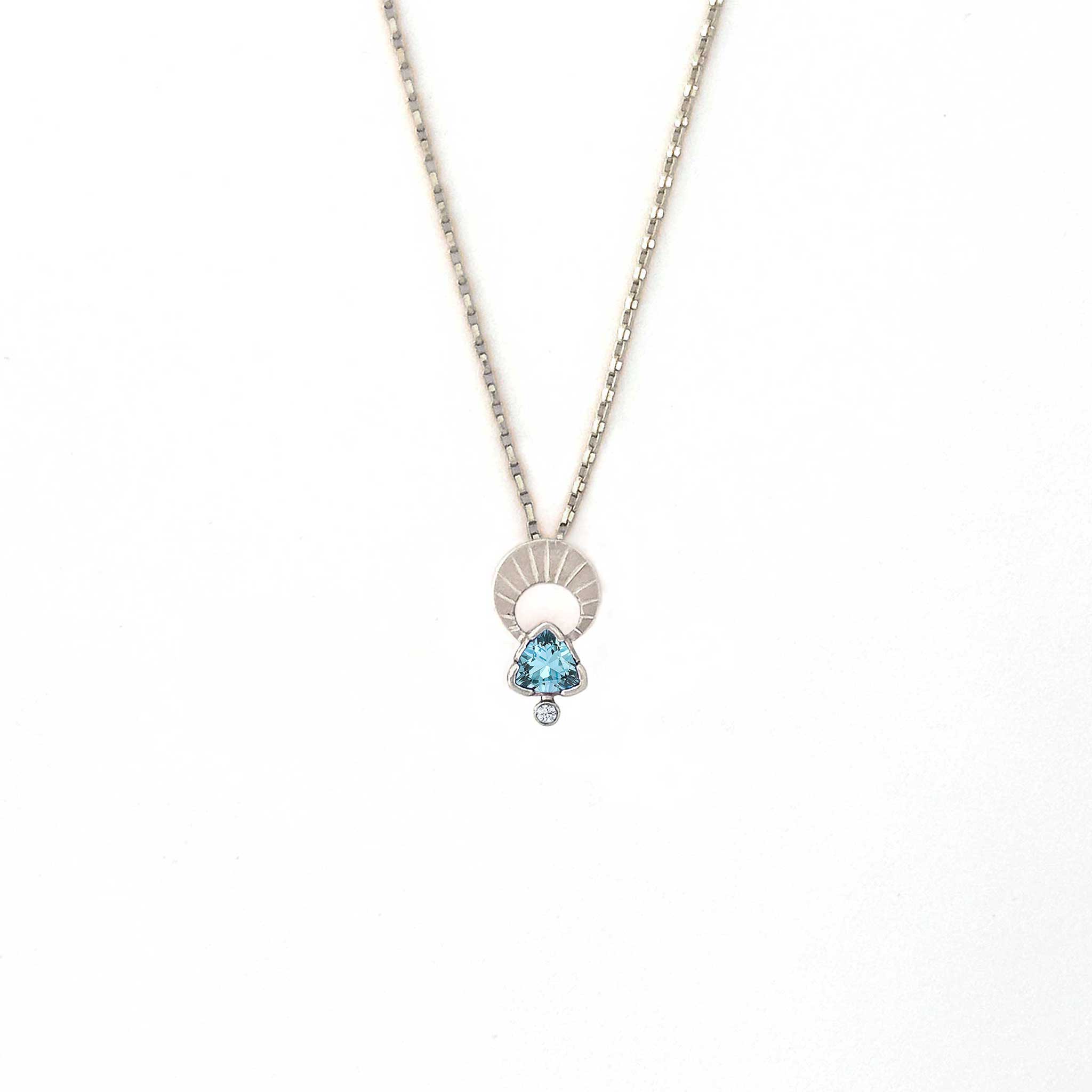 Crescent moon charm necklace with a trillion aquamarine and diamond pendant on a white background | Camille Torres Designs