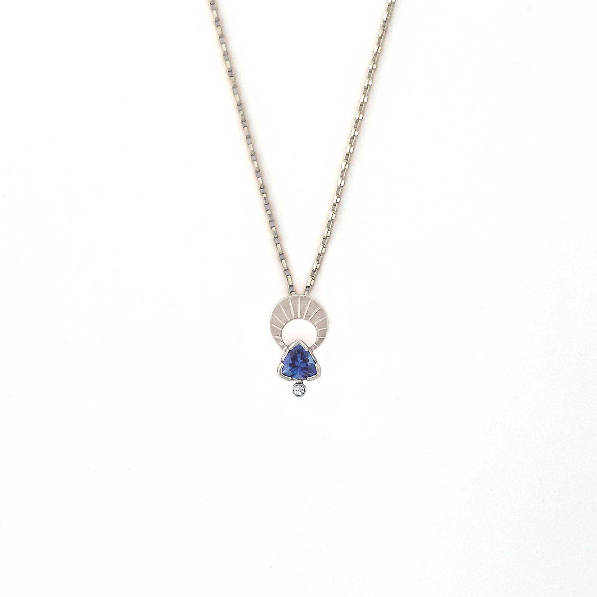 Crescent moon charm necklace with a trillion tanzanite and diamond pendant on a white background | Camille Torres Designs