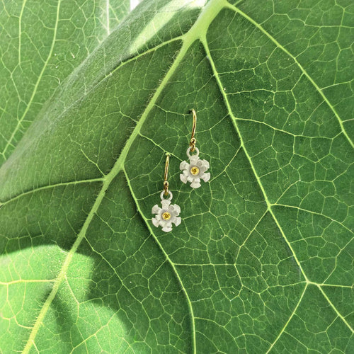 Blossom dangle earrings with matte white silver petals and 1.7 mm yellow sapphire, gold filled ear wires, on leaf