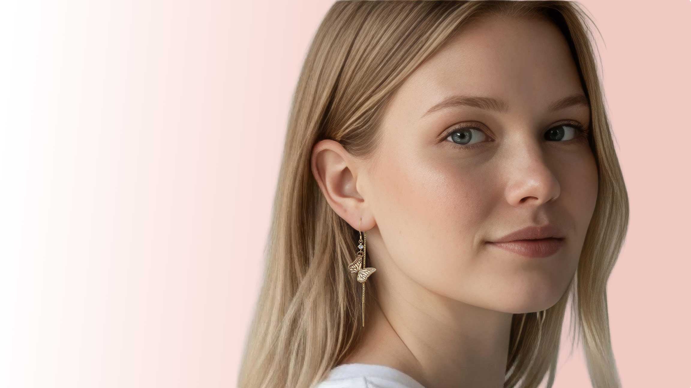 Woman wearing a Whisper butterfly gold and diamond earring threader against a pink background