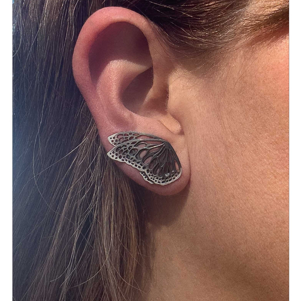 Close up of patina silver butterfly ear climber with silver edge. 