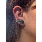 Close-up of ear wearing an oxidized silver Flight butterfly wing ear climber 