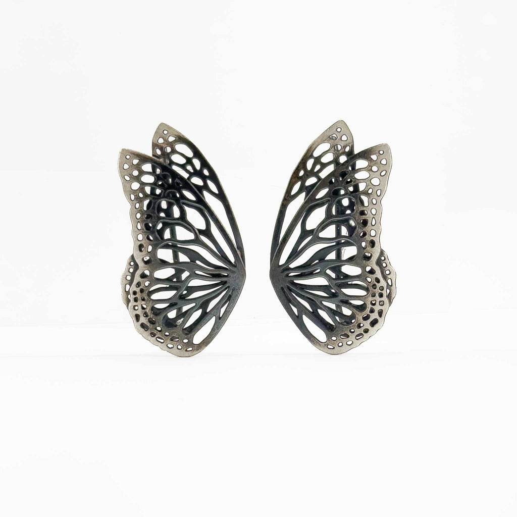 Flight butterfly wing oxidized silver earrings climbers  on a white background