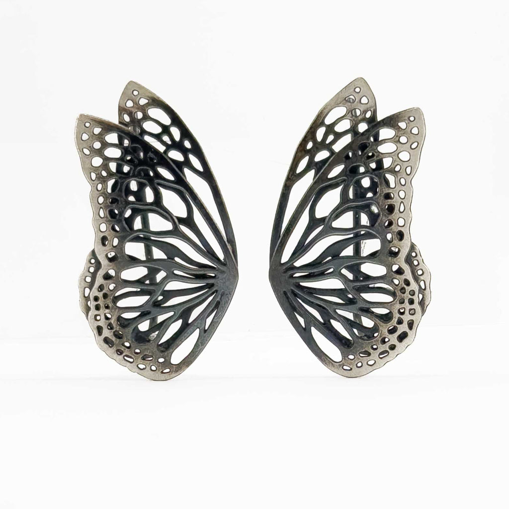 Flight butterfly oxidized silver ear crawlers  on a white background. 