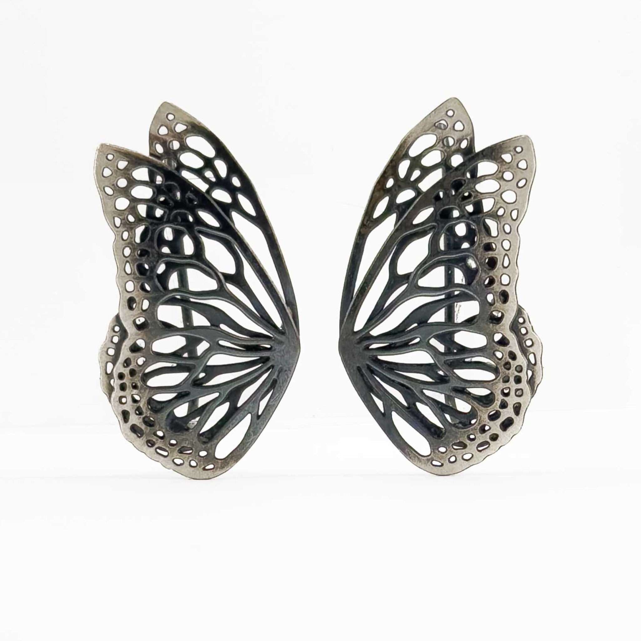 Flight butterfly oxidized silver ear crawlers  on a white background. 