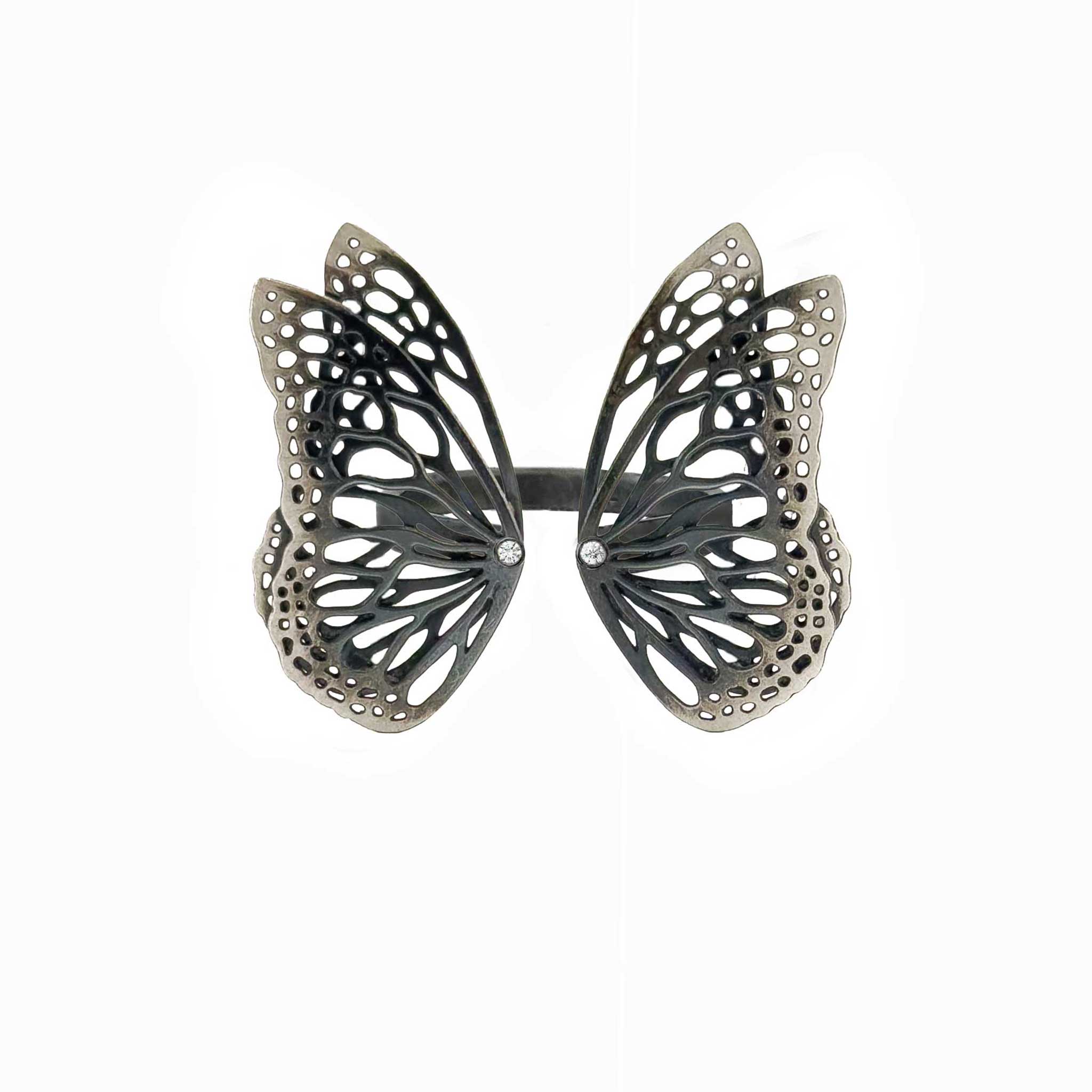 Migration butterfly ring in oxidized sterling silver with intricate cutout wing pattern, 1-inch adjustable band and Diamond accents over a white background | Camille Torres Designs
