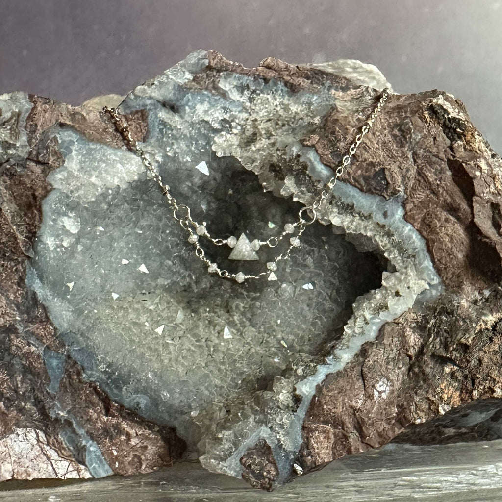 Silver necklace with triangle raw grey diamond pendant on a geode crystal