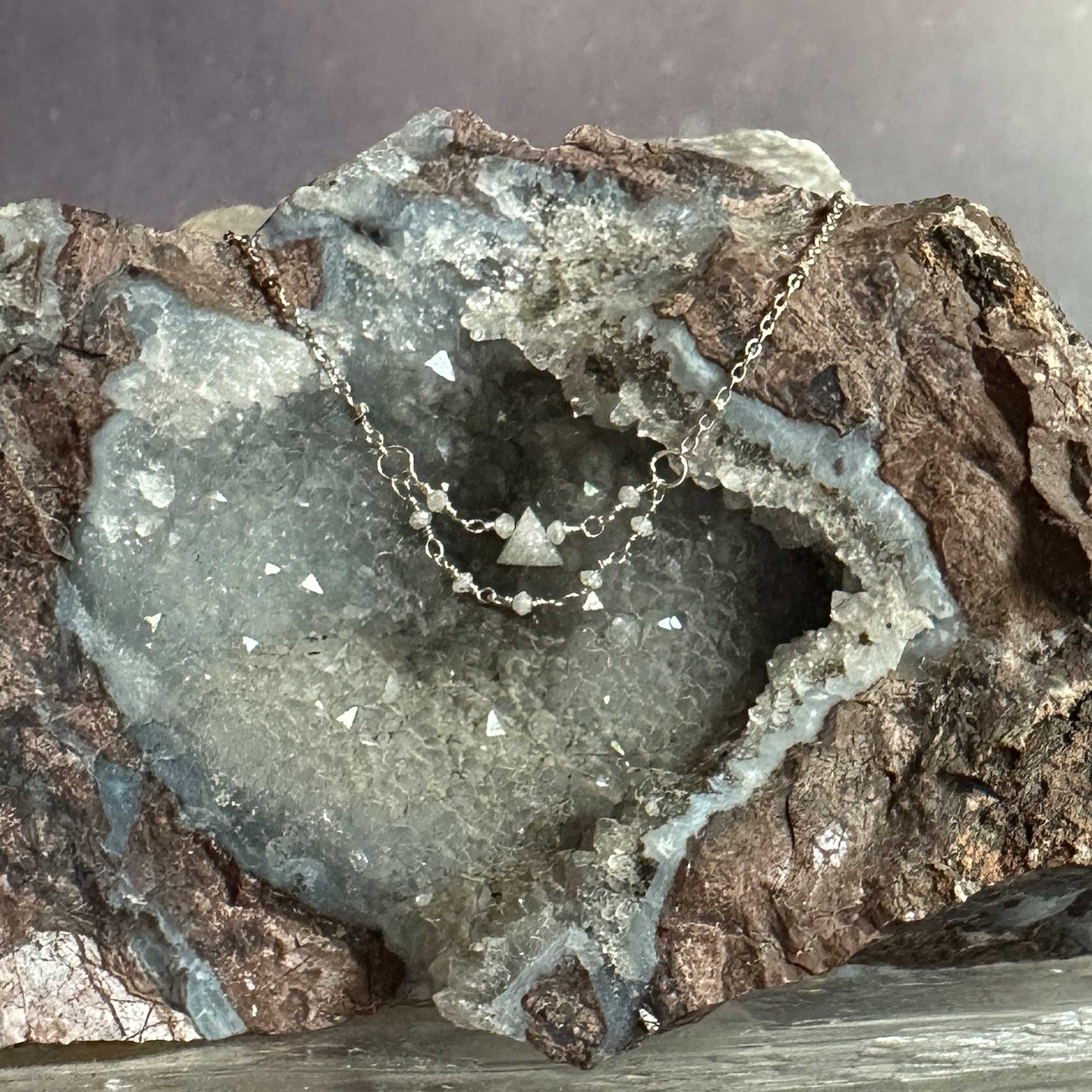 Silver necklace with triangle raw grey diamond pendant on a geode crystal