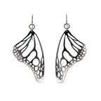 Monarch butterfly wing-shaped black and silver earrings on a white background