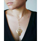 Gold Metamorphosis lariat with butterfly wings  pendant worn by a model