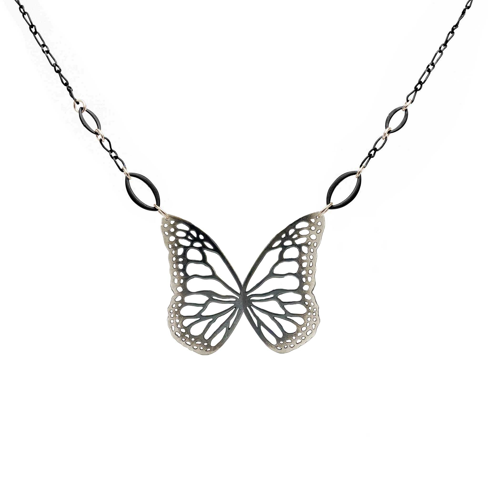 Black and silver butterfly-shaped pendant on a chain against a white background