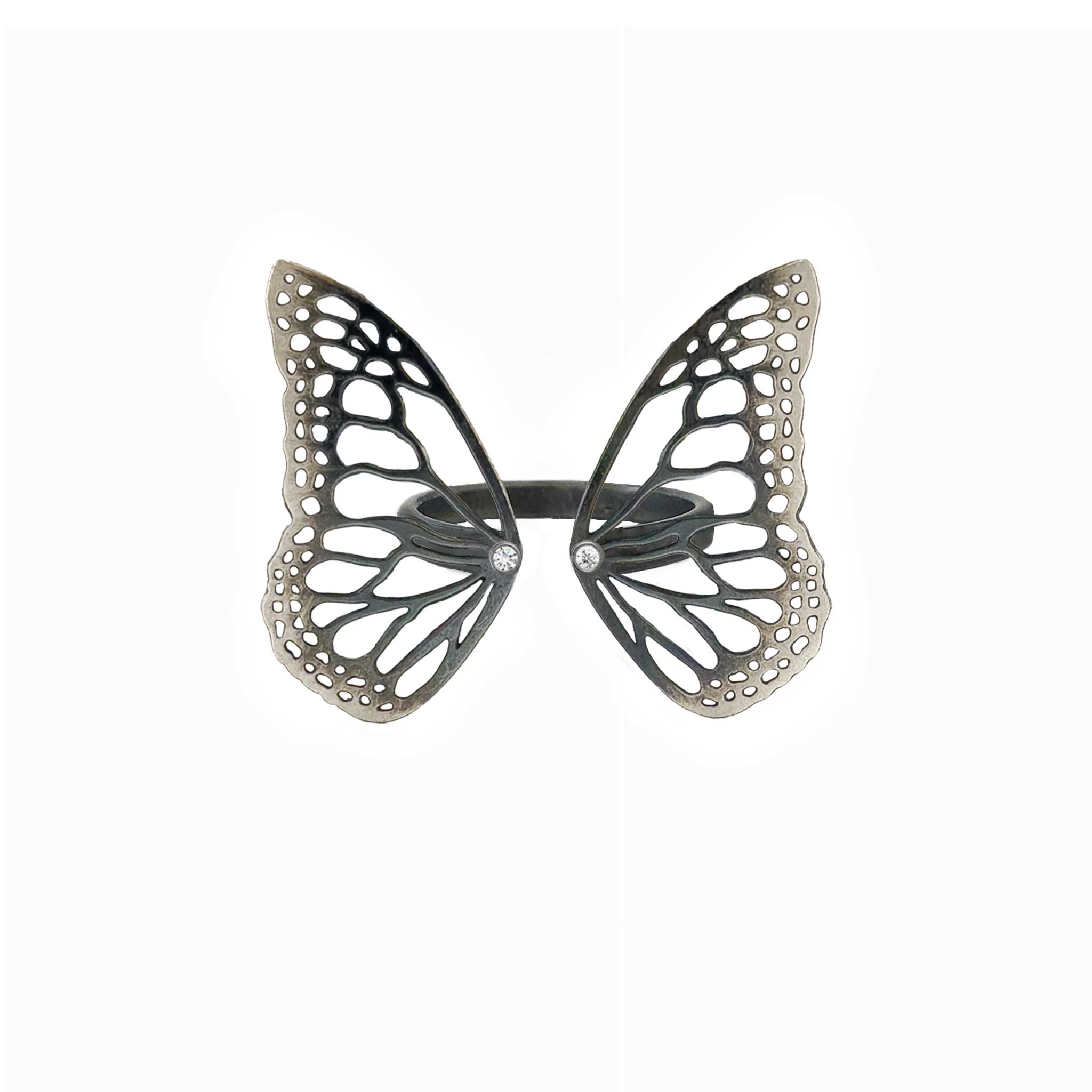 Migration butterfly ring in oxidized sterling silver with intricate cutout wing pattern, 1-inch adjustable band and Diamond accents over a white background | Camille Torres Designs