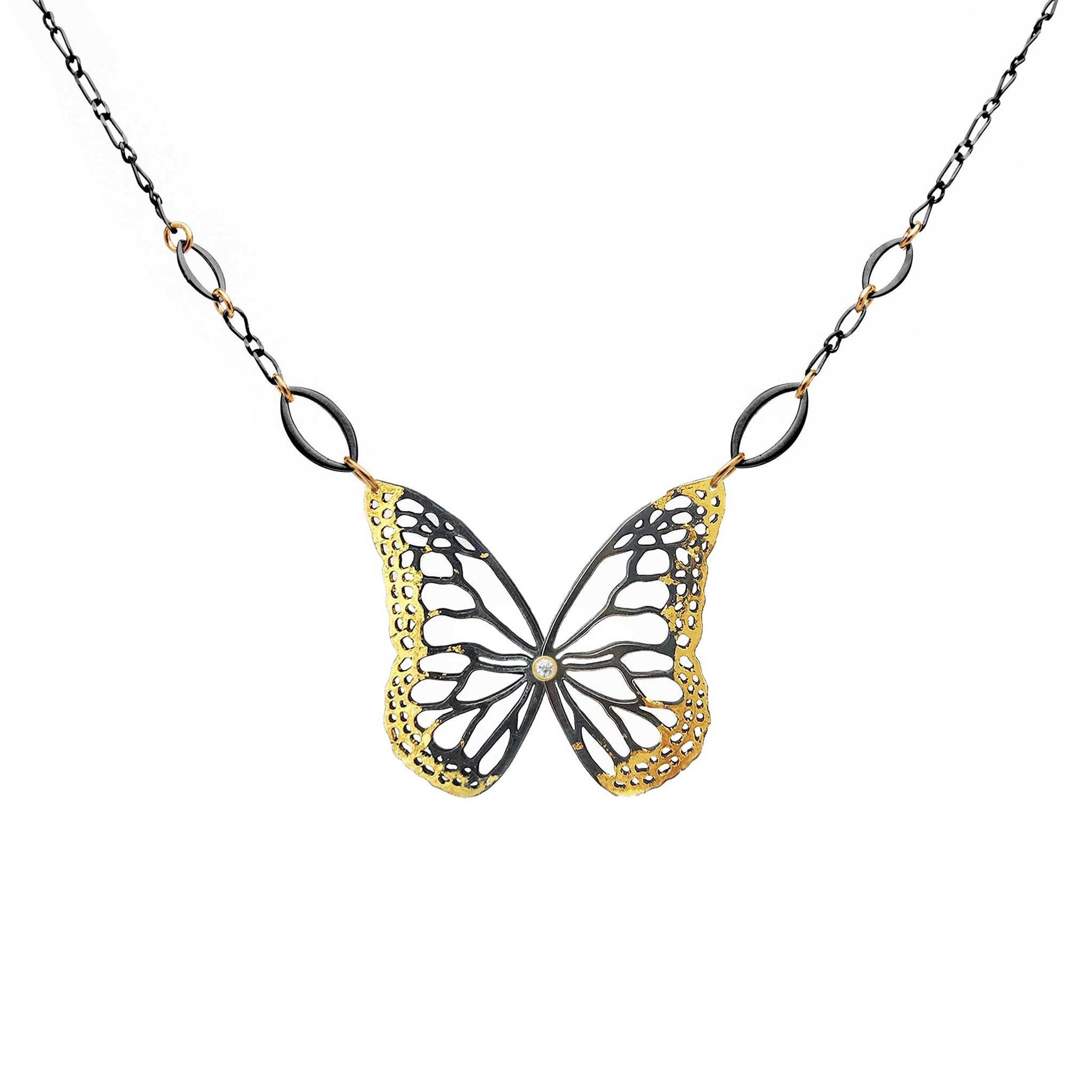 Butterfly necklace with 24k gold, black  silver and diamond on a white background