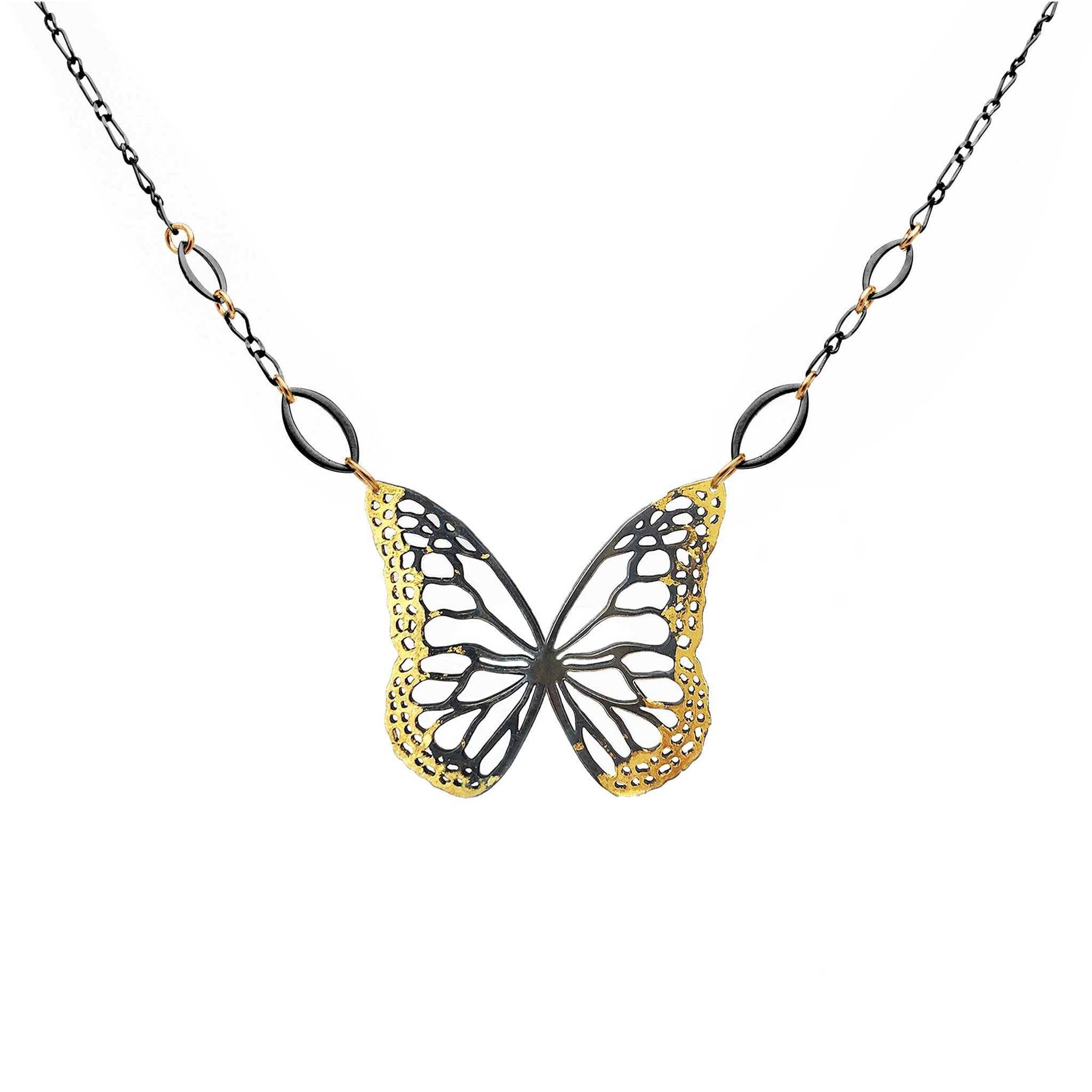 Butterfly necklace with mixed metal gold and black design on a white background