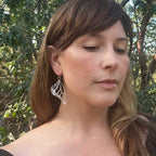 Camille wearing a silver Monarch earring with a natural background