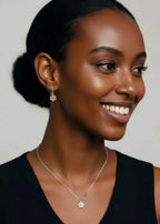 Woman wearing Blossom mixed metal silver charm necklace and drop earrings with yellow sapphire centers and 14k gold accents on a neutral background | Camille Torres Designs