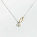 Flower pendant mixed metal necklace with a silver floral pendant and a diamond center set in gold on a white background | Camille Torres Designs