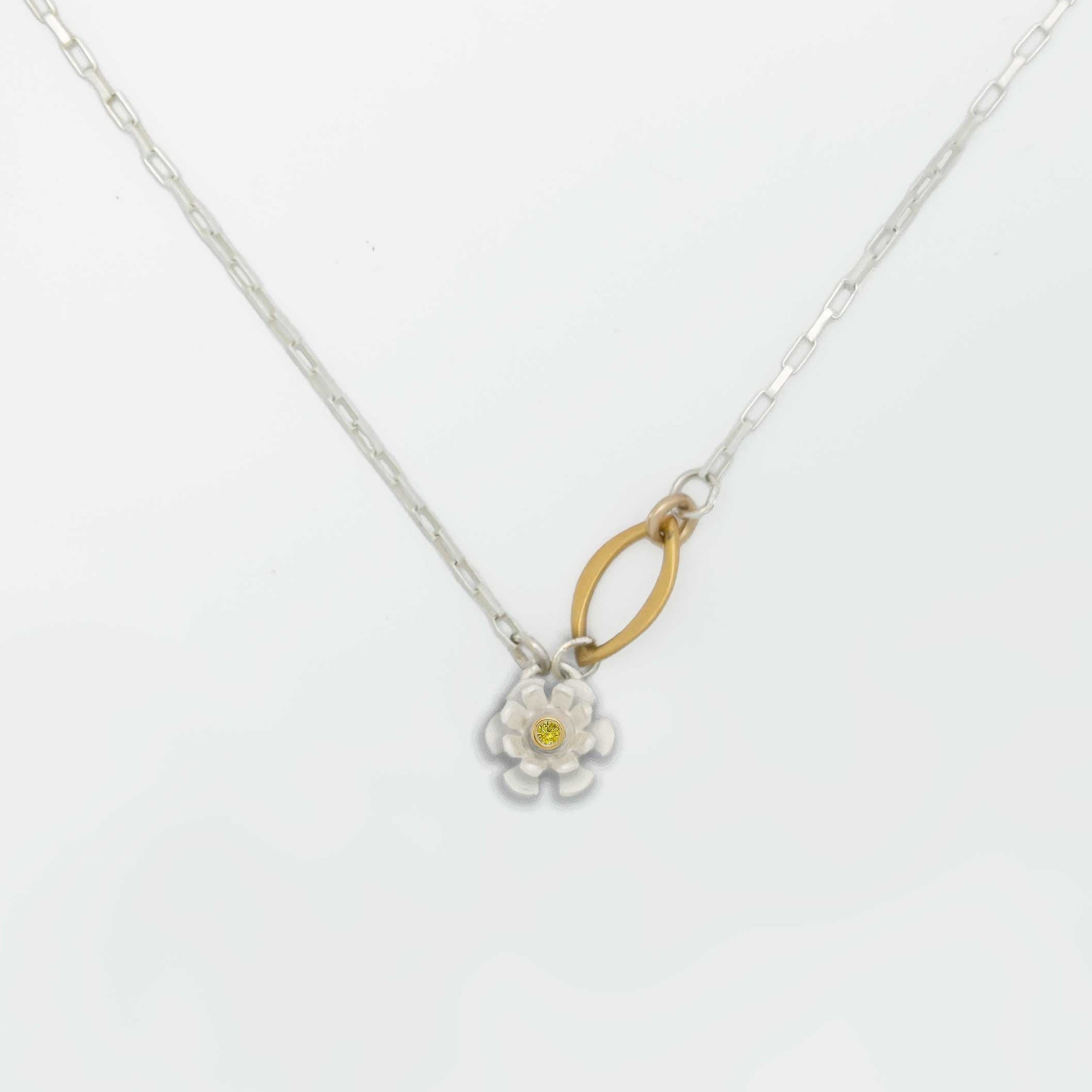 Flower charm necklace with a floral pendant and a gold and sapphire center on a white background | Camille Torres Designs