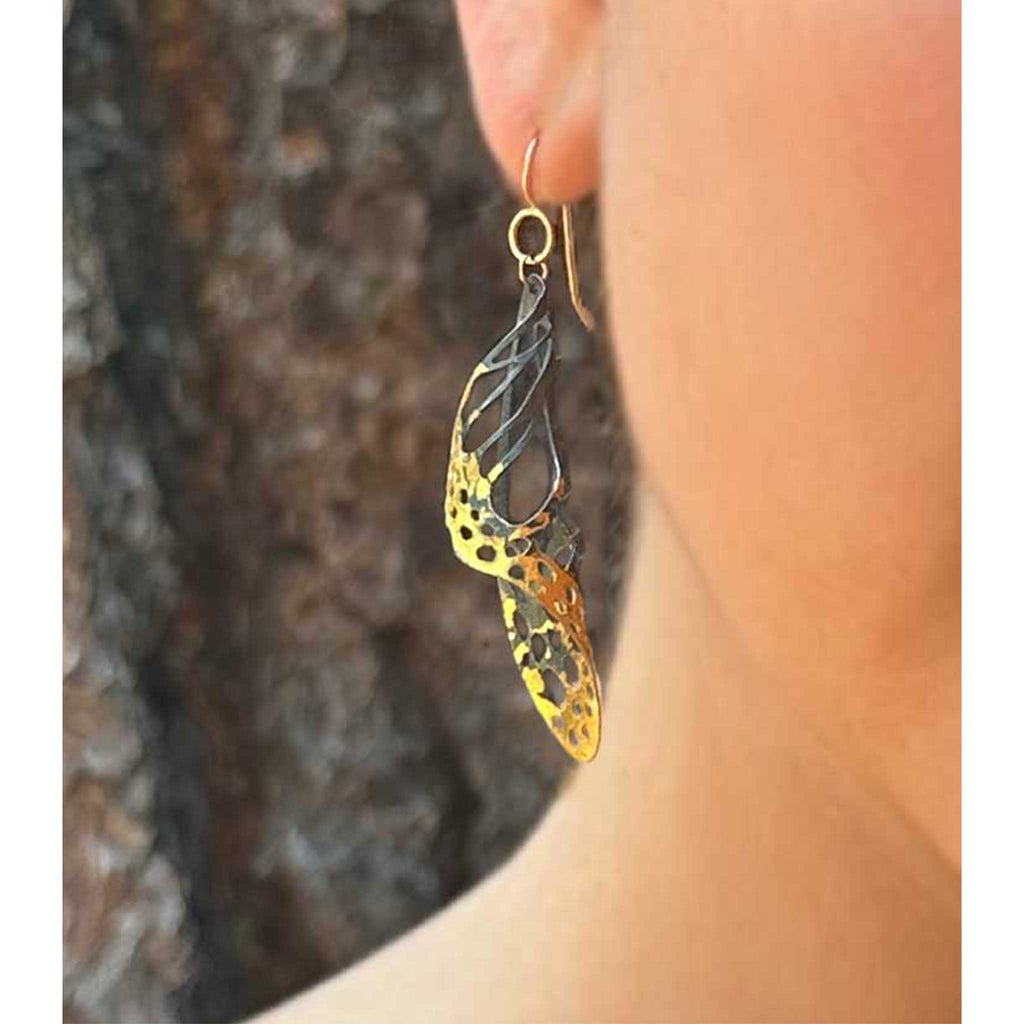 Chrysalis Keum-boo butterfly earrings worn on an ear with a blurred background