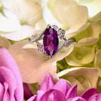 Custom colored gem engagement ring with floral vines in 18k white gold one a bed of flowers | Camille Torres Designs