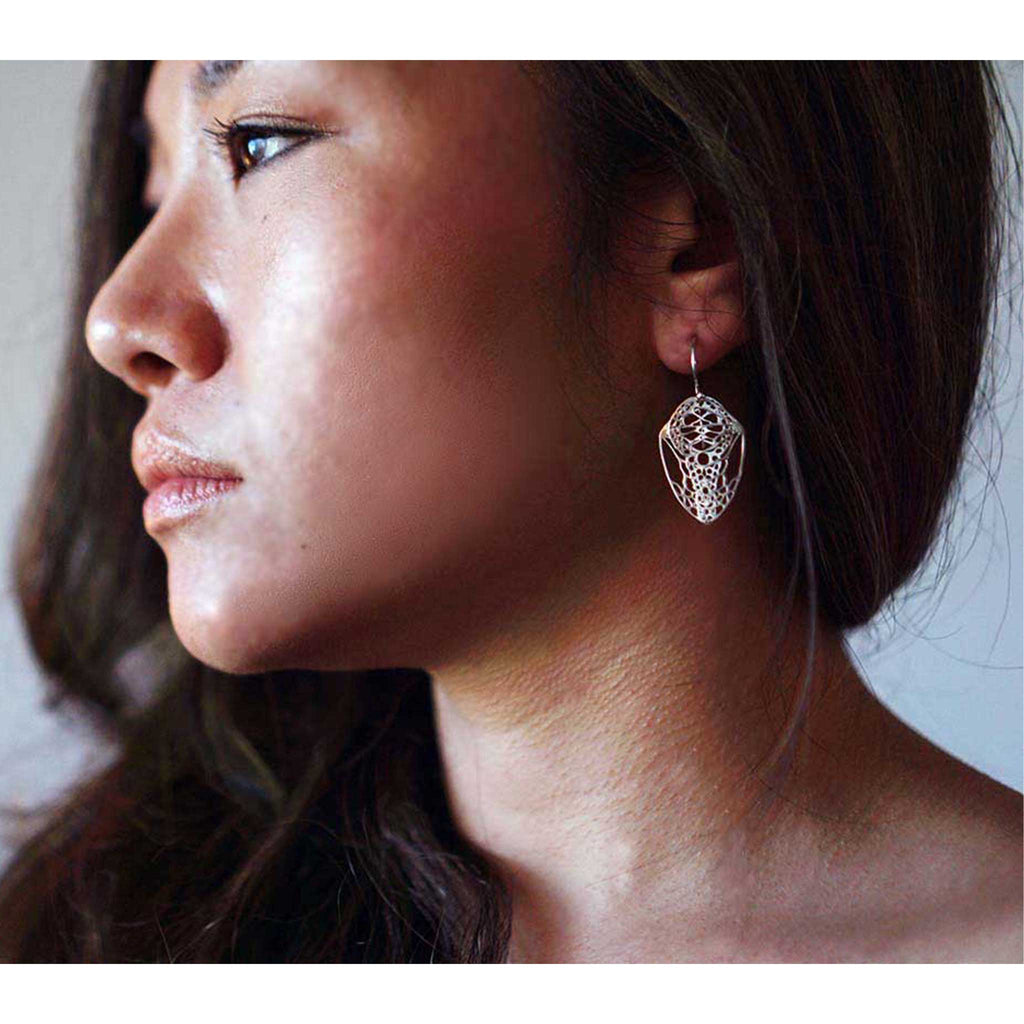 Close-up of a woman wearing a handcrafted sterling silver Cocoon butterfly drop earring