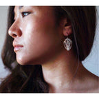 Close-up of a woman wearing a handcrafted sterling silver Cocoon butterfly drop earring