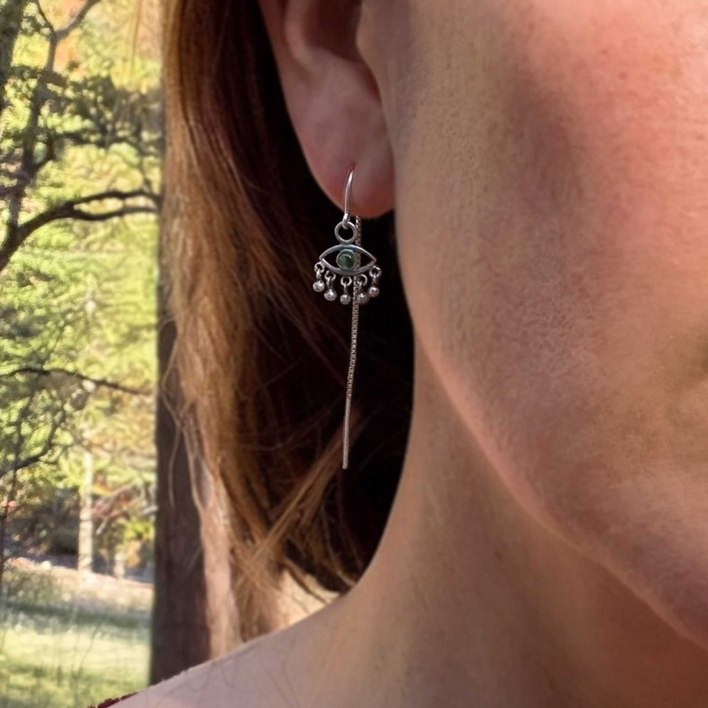 Sentinel evil eye silver threaders with green tourmaline up close on an ear | Camille Torres Designs