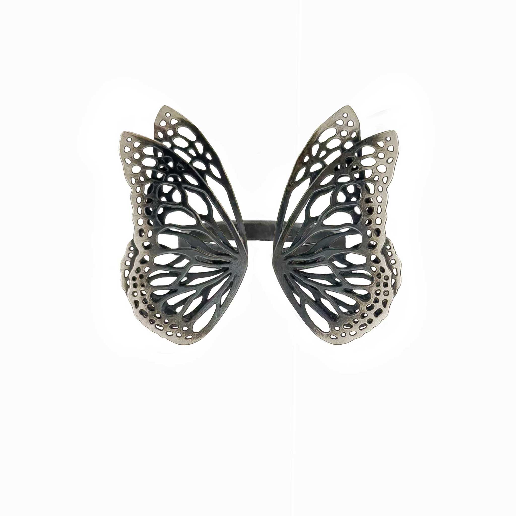Flight butterfly ring in oxidized sterling silver with intricate cutout wing pattern, 1-inch adjustable band over a white background | Camille Torres Designs