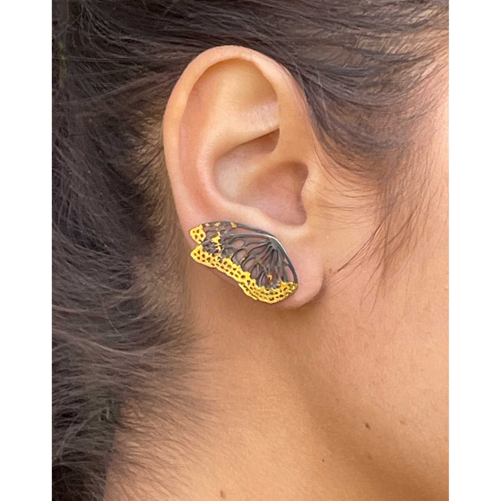 Flight monarch wing keum-boo ear climber  worn on an ear with a neutral background