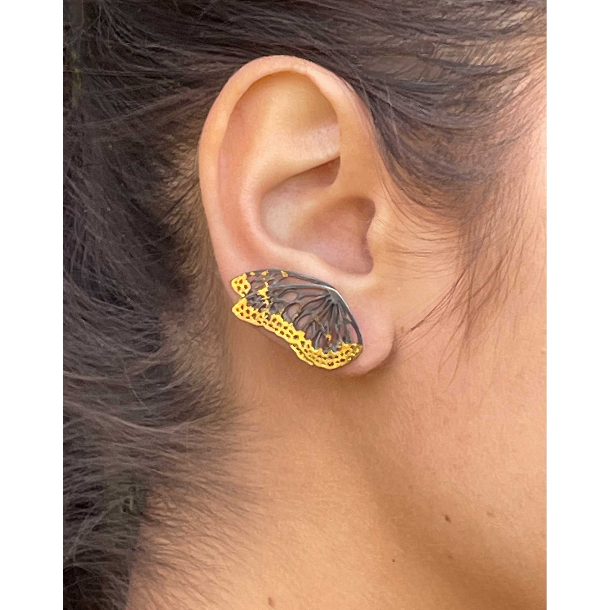 Flight monarch wing keum-boo ear climber  worn on an ear with a neutral background