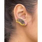 Flight monarch wing keum-boo and sapphire ear climber  worn on an ear with a neutral background