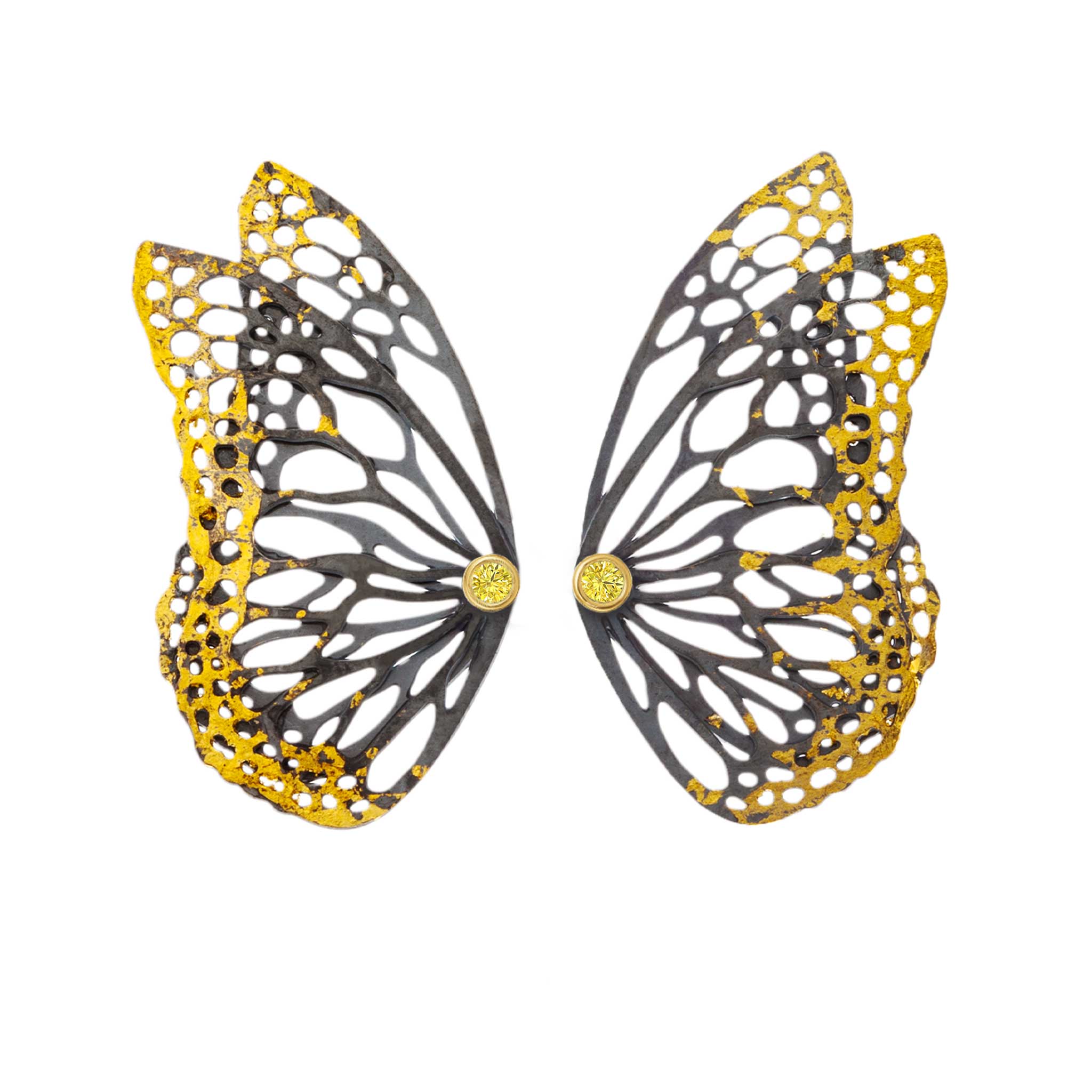 Butterfly wing-shaped earring with gold and black design with yellow sapphires on a white background