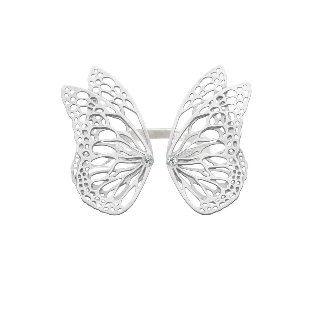 Flight butterfly ring in bright sterling silver with intricate cutout wing pattern, 1-inch adjustable band and Diamond accents over a white background | Camille Torres Designs