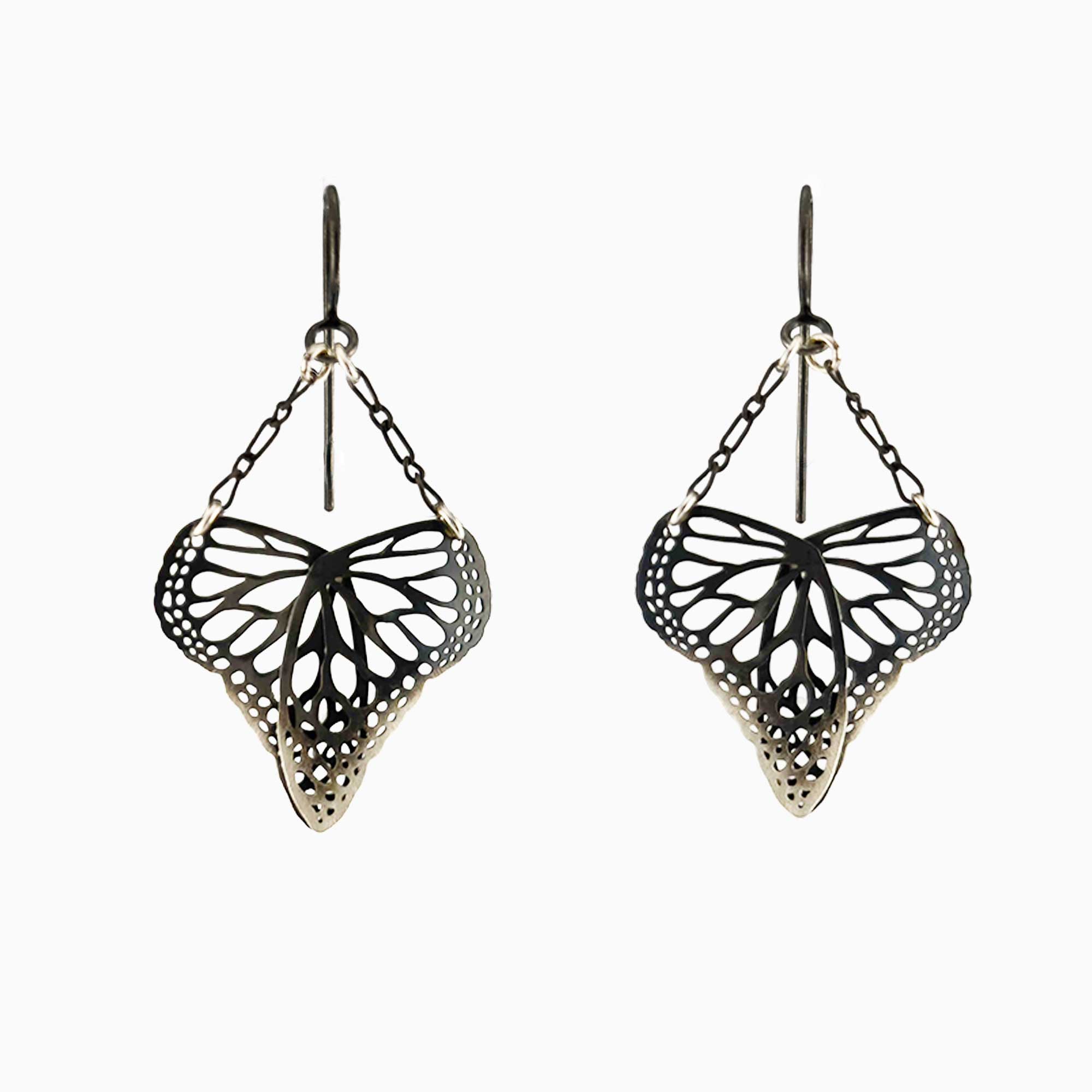 Oxidized silver heart-shaped butterfly drop earrings suspended from delicate chain on a white background | Camille Torres Designs
