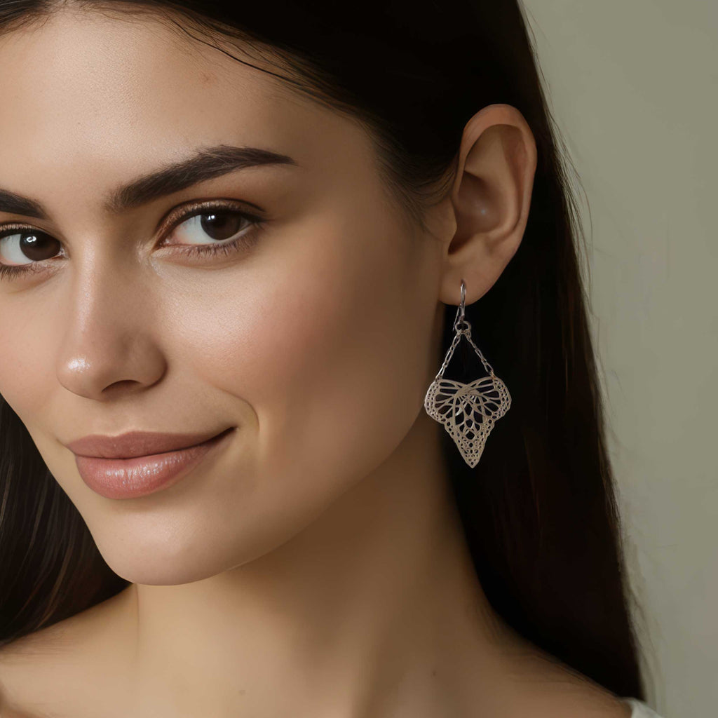 Woman wearing silver Flutter butterfly earrings and a neutral background