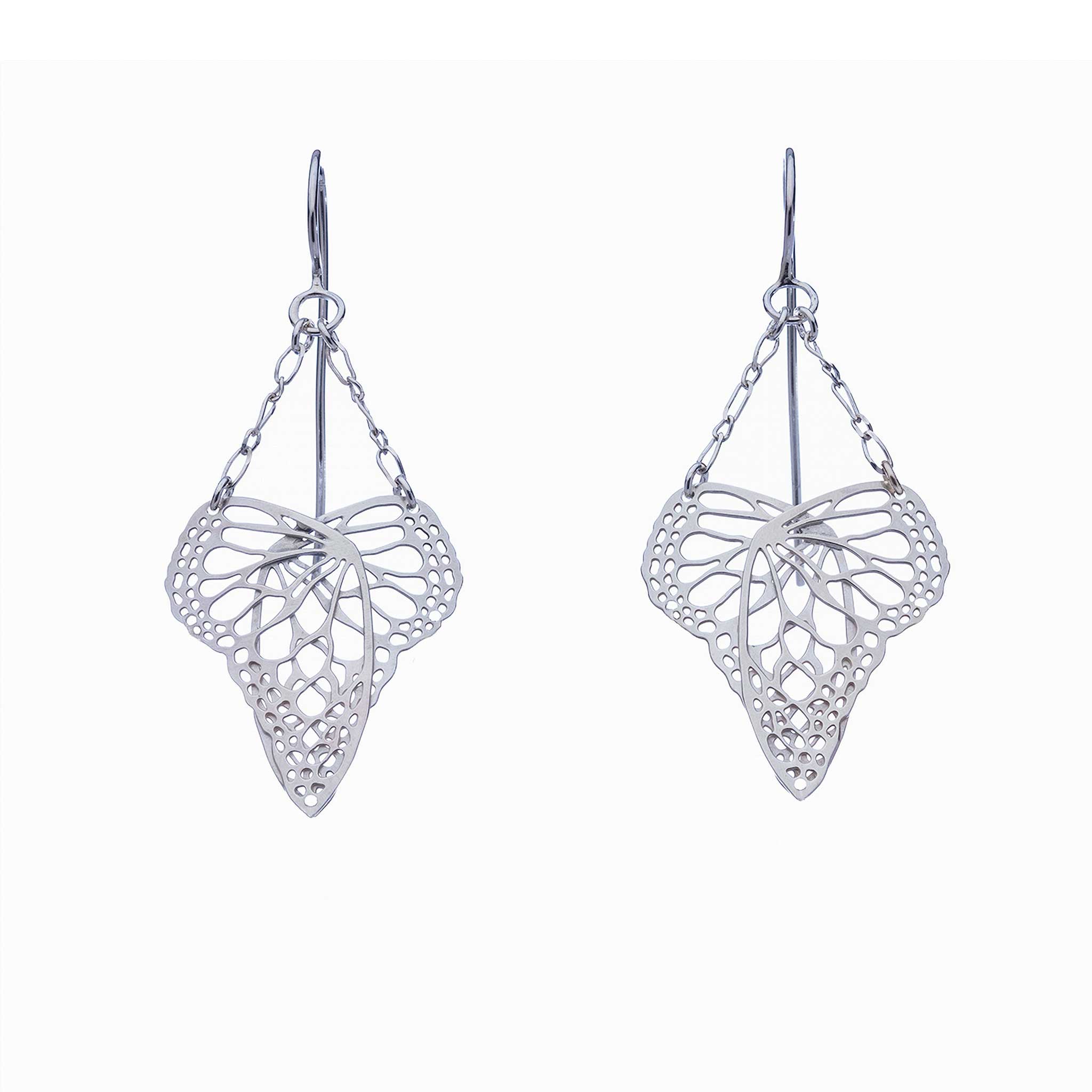 Pair of handcrafted silver heart-shaped butterfly drop earrings suspended from delicate chain on a white background | Camille Torres Designs