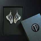 Silver Monarch butterfly earrings in a gift box with a black background