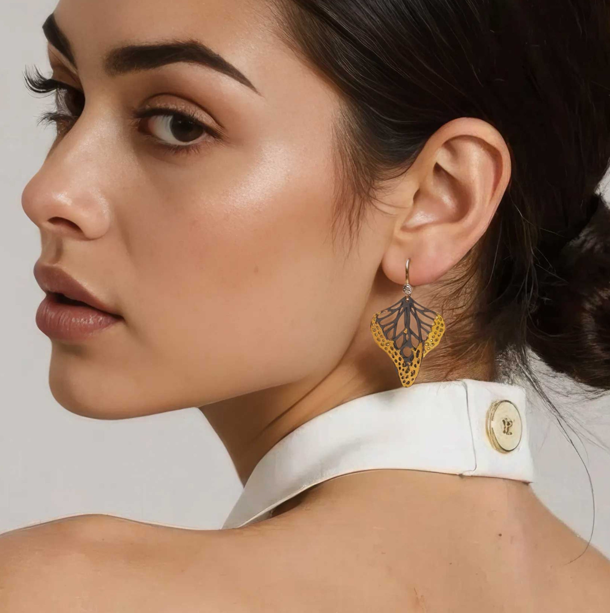 Woman wearing handmade butterfly mixed metal keum-boo drop earrings with 14k gold and diamonds 