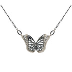 The Migration oxidized silver butterfly pendant necklace with diamond center and overlapping, 2 wing design, suspended from a delicate silver chain against a plain white background.