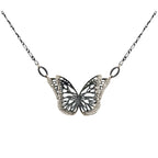 The Migration oxidized silver butterfly pendant necklace with overlapping, 2 wing design, suspended from a delicate silver chain against a plain white background.