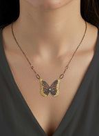 Migration butterfly keum-boo with sapphire necklace on a model wearing a dark top