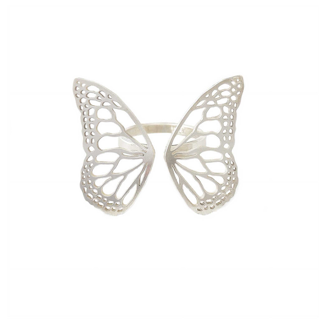 Migration butterfly ring in bright sterling silver with intricate cutout wing pattern, 1-inch adjustable band over a white background | Camille Torres Designs