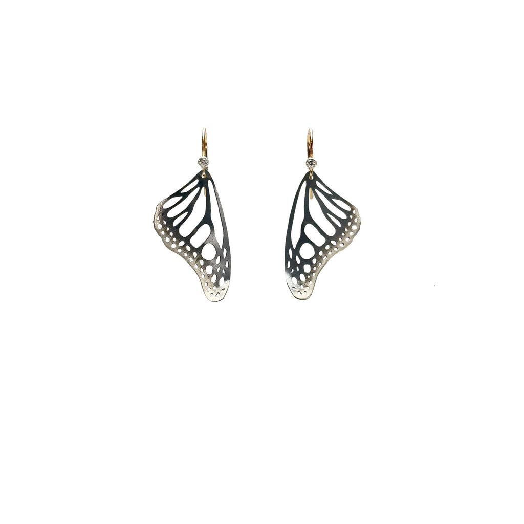 Handmade small Monarch butterfly drop earrings in oxidized silver with 14k gold and diamond ear wires over a white background | Camille Torres Designs