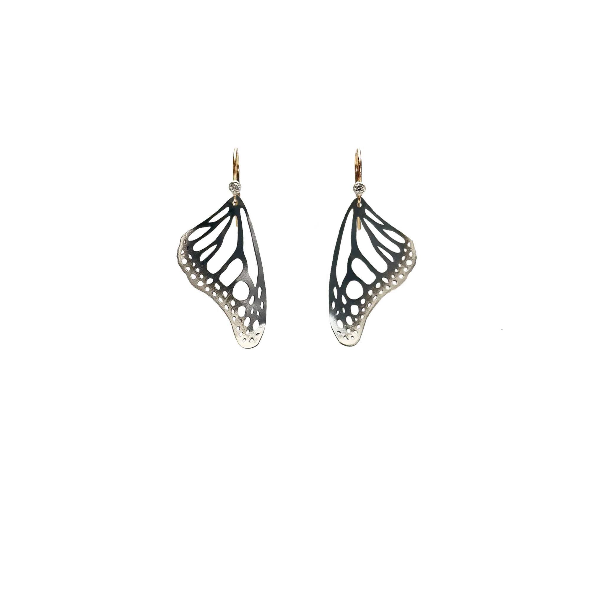 Handmade small Monarch butterfly drop earrings in oxidized silver with 14k gold and diamond ear wires over a white background | Camille Torres Designs