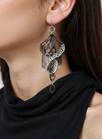 Close-up of a person wearing Overwinter butterfly chandelier oxidized silver earrings 