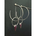 Side view of Ruby Halo Hoops showing dimensional layering of ruby jacket hoop behind 2-inch sterling silver hoop on dark background