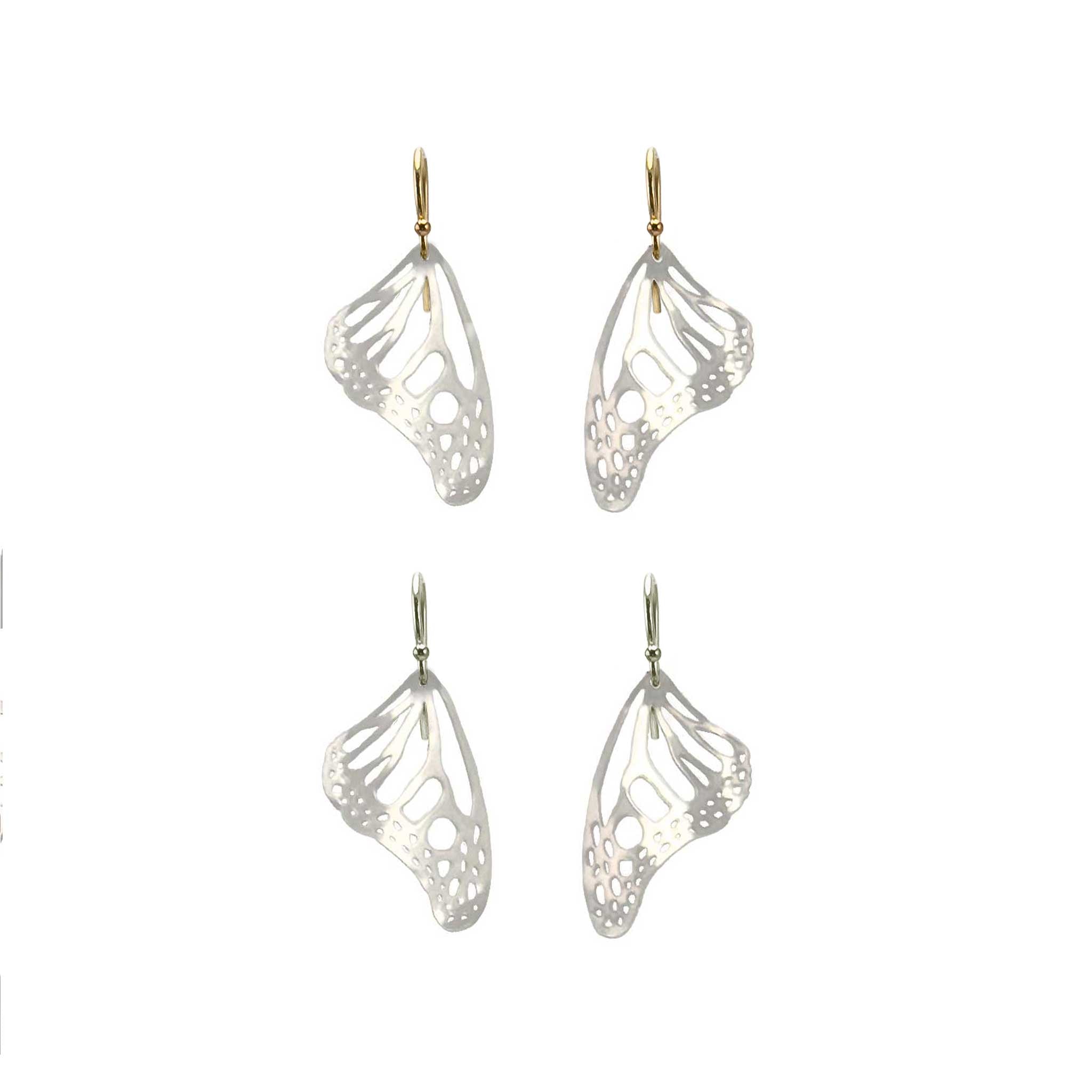 Two pairs of silver Monarch butterfly-wing shaped earrings with gold and silver ear wires on a white background