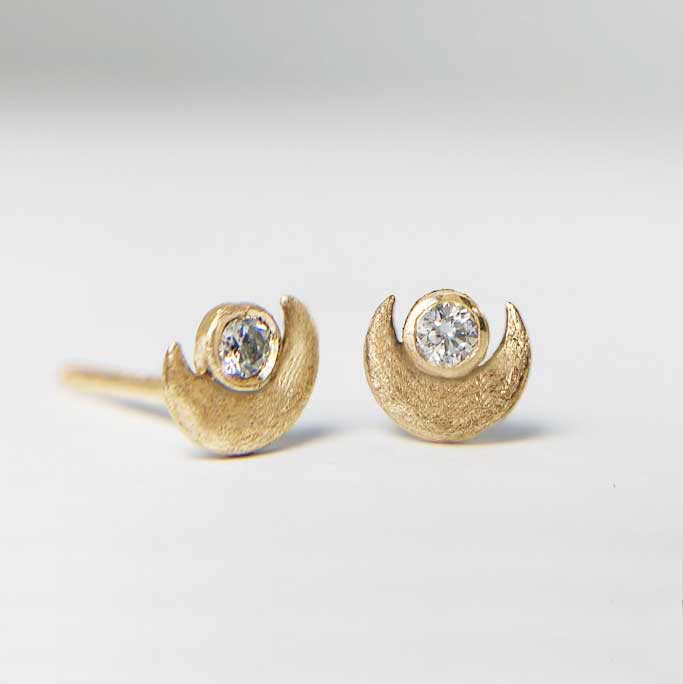 Yellow gold crescent moon stud earrings with diamond accent at dark side of the moon on a white background. Camille Torres Designs
